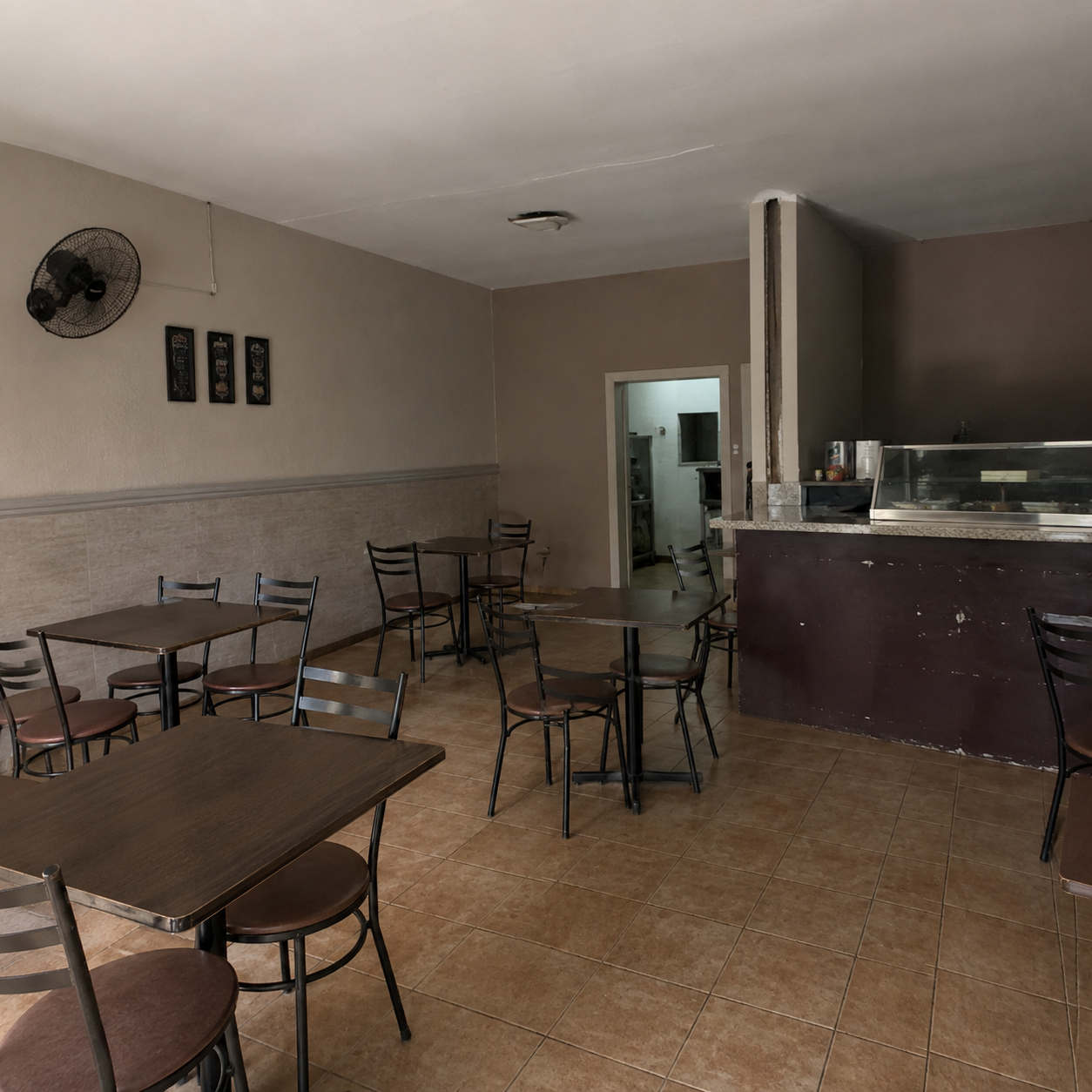 Interior con mesas y sillas vacías, sin decoración